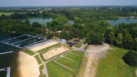 Aerial-Drone-rises-up-Over-Natural-Swimming-Pool-During-Daytime-In-Kaniow,-Poland