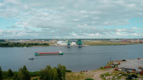 Aerial-view-of-cargo-ship-sailing-along-the-port