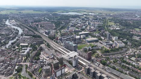 Leiden,-Holanda-Meridional,-Vista-Aérea-De-La-Ciudad-Con-Drones,-Edificios-E-Infraestructura-De-Estaciones-De-Tren