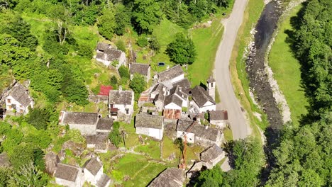 Aerial-view-of-a-scenic-and-rustic-village-with-traditionally-built-homes-in-Maggiatal-Vallemaggia,-Tessin,-Switzerland