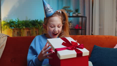 Niña-Feliz-Sostiene-Una-Caja-De-Regalo-De-Cumpleaños-Con-Cinta,-Celebrando-La-Fiesta,-Abriendo-El-Regalo-En-Casa