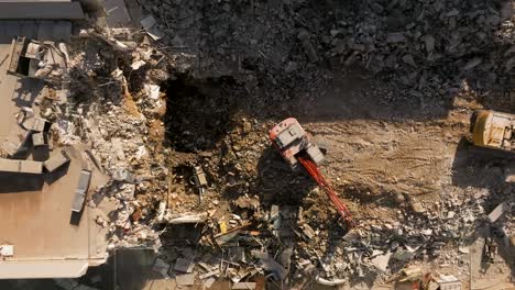 Excavator-demolishing-a-residential-building,-Aerial-view