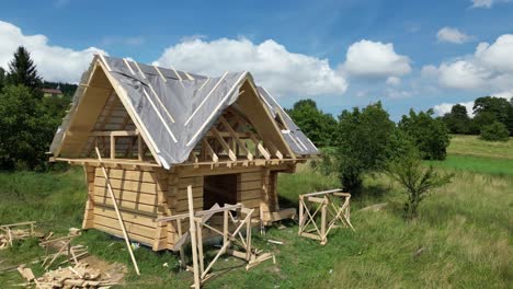 Casa-De-Madera-En-Construcción,-Hecha-De-Troncos-Y-Ubicada-En-Un-Hermoso-Paisaje---Vista-Aérea-4k