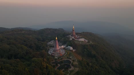 4K-aerial-drone-footage-of-pagodas-in-Doi-Inthanon-during-a-sunset,-Chiang-Mai,-Thailand,-Asia