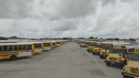 A-dolly-shot-zooms-out,-revealing-rows-of-the-Clear-Creek-ISD-school-bus-fleet-ready-to-start-the-school-year-in-League-City,-Texas