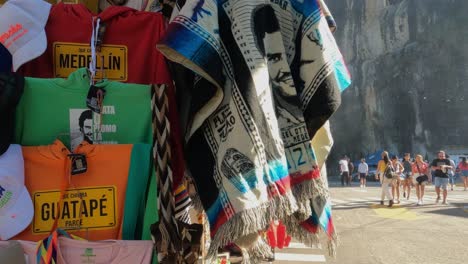 Tienda-De-Souvenirs-Y-Camisetas-Con-Foto-Policial-De-Pablo-Escobar-En-El-Peñol,-Lago-De-Guatapé,-Colombia