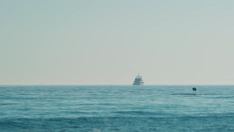 Vista-Desde-La-Costa-De-Un-Yate-De-Lujo-En-El-Mar-Mediterráneo,-Con-Un-Grupo-De-Buceadores-Más-Cerca.