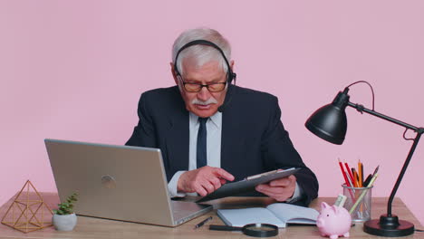 Senior-businessman-in-headphones-making-conference-video-call-on-laptop,-call-center-agent,-operator