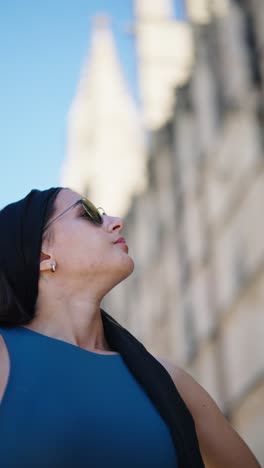 Low-angle-approach-toward-female-put-sunglasses-in-sunny-Mallorca-vacation