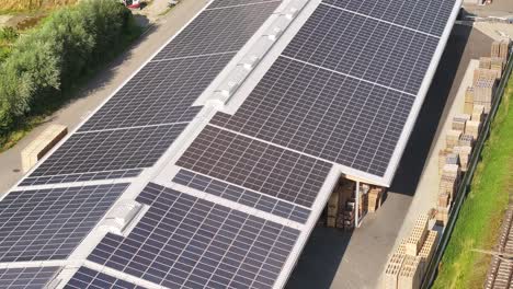 Solar-panels-on-an-industrial-building-roof-near-a-railway-in-Weesen,-Glarus,-Switzerland