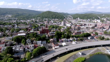 Downtown-Cumberland,-Maryland-with-freeway-traffic-with-drone-video-pulling-back