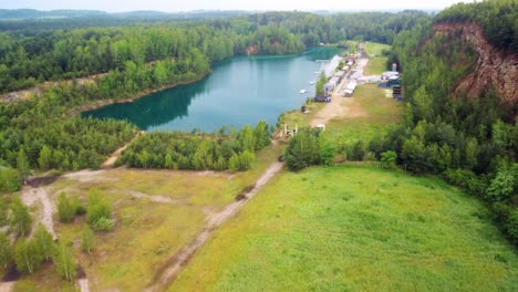 Drone-shot-of-Grodek-Park-diving-center-located-on-the-Wydra-Reservoir-with-lush-greenery-and-turquoise-water-in-Jaworzno,-Silesian-province