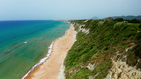 Aerial-drone-shot-over-the-long-stretching-empty-sandy-beach-in-Corfu-in-Greece