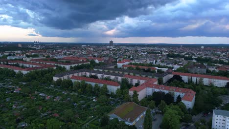 Modernes-Europäisches-Stadtbild-Mit-Wohngebäuden,-Einer-Autobahn-Und-üppigen-Grünflächen-Unter-Einem-Bewölkten-Himmel-Bei-Sonnenuntergang