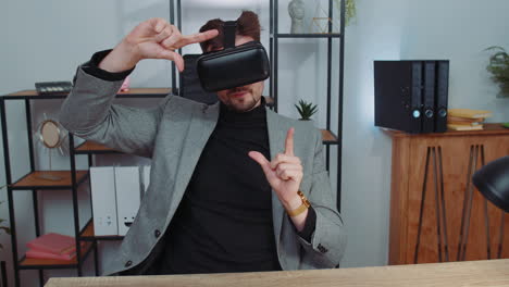 Businessman-working-using-virtual-reality-futuristic-technology-VR-app-headset-helmet-at-home-office