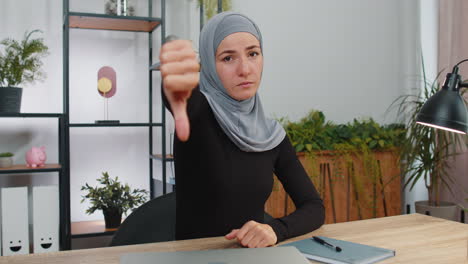 Upset-young-muslim-business-woman-showing-thumbs-down,-dislike,-discontent,-disapproval,-bad-work