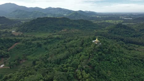 Estupa-Dorada-De-Phra-Maha-Chedi-Thep-Nithakorn-Con-Paisaje-Circundante-De-Colinas-Y-Montañas-Cerca-De-Khao-Yai,-Tailandia