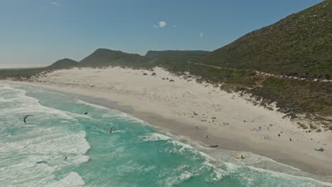 Toma-Aérea-De-Un-Día-Ajetreado-Con-Kitesurfistas-En-Misty-Cliff-Cerca-De-Ciudad-Del-Cabo