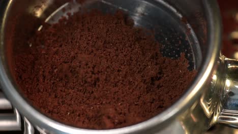 Close-up-of-freshly-ground-coffee-beans,-coffee-grinding