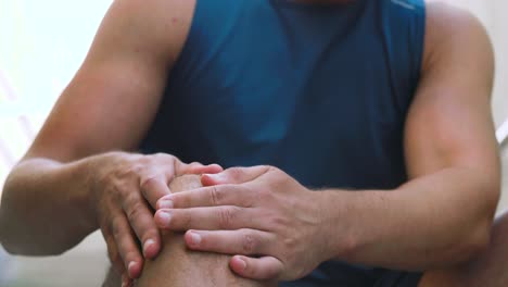 Junger-Mann-Massiert-Verletztes-Bein,-Während-Er-Auf-Einer-Treppe-Sitzt.-Fitness-,-Sport--Und-Gesundheitskonzept-Junger-Mann-Massiert-Verletztes-Bein-Oder-Knie,-Während-Er-Auf-Einer-Treppe-Sitzt