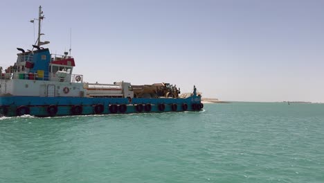 Overtaking-ferry-barge-carrying-heavy-trucks-on-water-of-Persian-Gulf