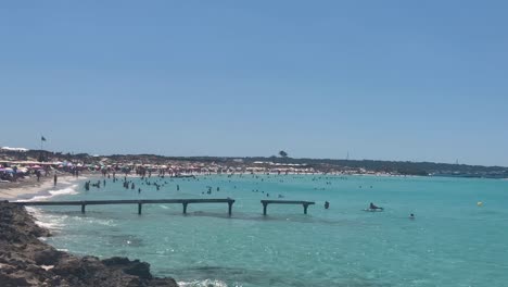 Sonniger-Strandtag-Auf-Mallorca-Mit-Leuten,-Die-Schwimmen-Und-Das-Klare-Blaue-Wasser-Genießen