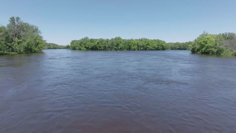 Toma-En-Movimiento-De-ángulo-Bajo-De-La-Superficie-Del-Agua-Del-Río-Mississippi-Y-El-Bosque-Tropical-Cercano-En-Minnesota,-EE.-UU.