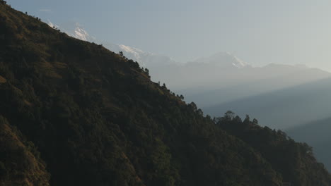 Landscape-of-Nepal,-hills-and-mountains-reflecting-sunrays,-showing-mesmerizing-nature,-Drone-Captures-the-stunning-beauty-of-natural-terrain-with-sunlit-peaks-and-serene-surroundings