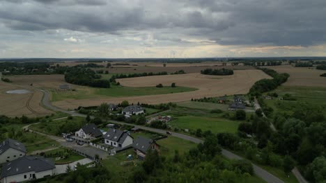 Ländliche-Szene-Eines-Bauerndorfes-Mit-Windturbinen-Im-Hintergrund-In-Polen