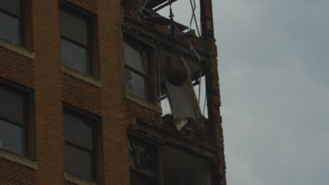 A-close-up-view-of-the-demolition-of-a-high-rise-building-in-Youngstown,-Ohio,-showing-significant-structural-damage-and-exposed-interior-components