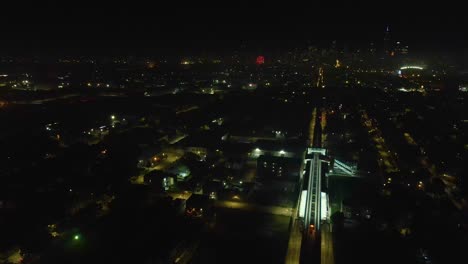 Vista-Aérea-Con-Dron-De-Un-Vibrante-Paisaje-Urbano-De-Chicago-Por-La-Noche,-Iluminado-Por-Deslumbrantes-Explosiones-De-Fuegos-Artificiales-A-Lo-Largo-De-Una-Bulliciosa-Calle-Principal