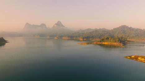 4K-Luftaufnahmen-Von-Einem-See-Und-Bergen-Im-Kao-Sok-Nationalpark-Bei-Sonnenaufgang,-Thailand,-Asien