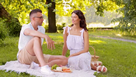 Glückliches-Paar-Mit-Essen-Beim-Picknick-Am-Strand.-Freizeit,-Beziehungen-Und-Menschen-Konzept-Glückliches-Paar-Mit-Essen,-Das-Trauben-Isst-Und-Am-Strand-Picknickt