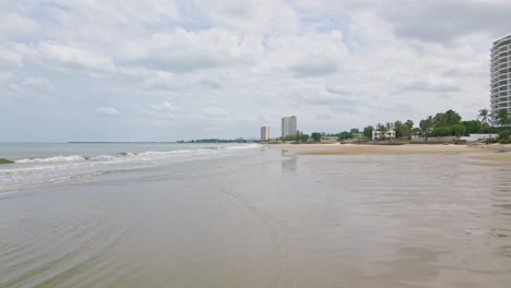 Cha-Am-Beach-in-Thailand-with-Low-Angle-Drone-Shot-Over-Wet-Sand