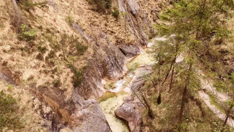 Aerial-view-of-the-Almbachklamm-waterfall-in-Garmisch-Partenkirche-during-summer-showcases-the-vibrant-display-of-colorful-foliage