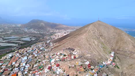 Vista-Aérea-De-La-Ciudad-De-Galdar,-Pueblo-Bajo-La-Montaña-Contra-El-Paisaje-Marino-En-Gran-Canaria,-España