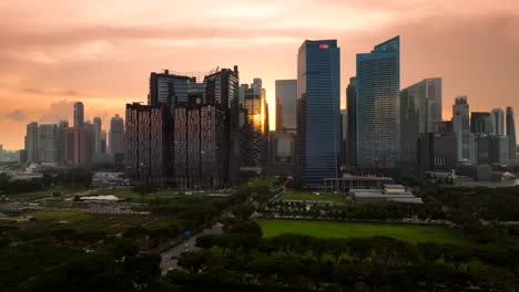 Luftaufnahme-Der-Skyline-Von-Singapur-Mit-Leuchtendem-Sonnenuntergang,-Der-Sich-In-Den-Gebäuden-Spiegelt