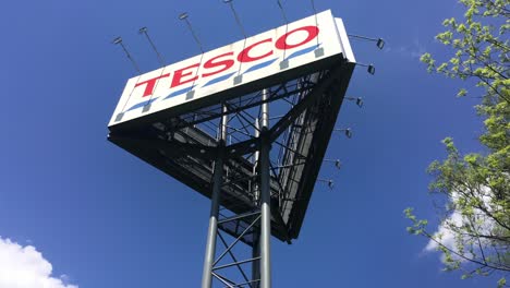 Großer-Dreieckiger-Werbebannerturm-Des-Kaufhauses-Tesco,-Vertikales-Schwenken