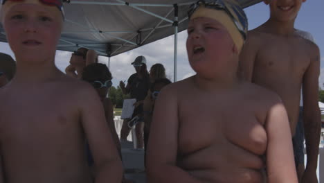 Joyful-children-in-swimwear,-making-funny-faces-and-waving-to-the-camera