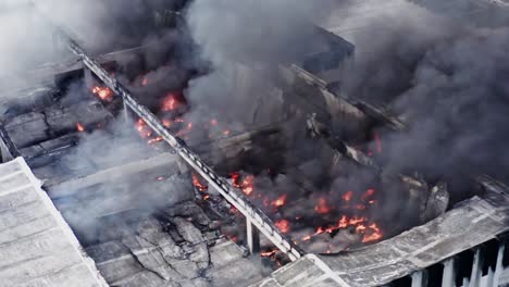 Aerial-view-of-urban-disaster-caused-by-structural-warehouse-fire-with-collapsed-roof