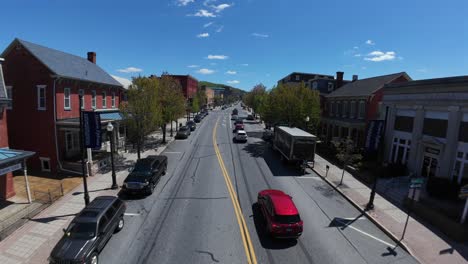 Drone-flight-over-american-town-with-pedestrian-and-traffic-on-main-street