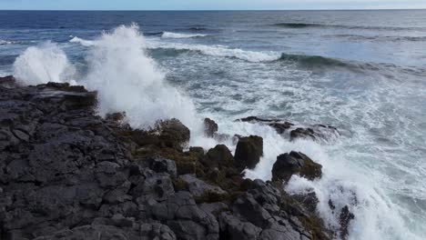 Wellen-Brechen-Gegen-Die-Felsige-Küste-Und-Erzeugen-Ein-Faszinierendes-Schauspiel-Aus-Weißem-Schaum-Und-Tiefblauem-Meer-Vor-Dem-Hintergrund-Eines-Hellblauen-Himmels