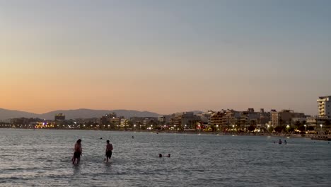 People-enjoying-the-beach-at-sunset-in-Mallorca,-Spain