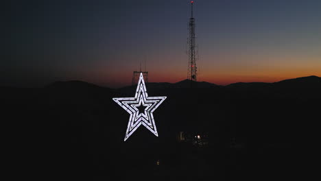 Downward-aerial-pan-of-Mill-Mountain-in-Roanoke-Virginia-at-warm-orange-sunset