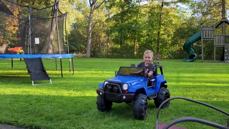 High-quality-footage-capturing-a-child-joyfully-playing-in-the-backyard-with-a-toy-car-and-playground-set