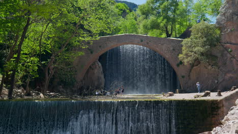 Toma-De-Establecimiento-Del-Puente-De-Arco-De-Piedra-De-Palaiokarya,-Grecia,-Cascada-En-Cámara-Lenta