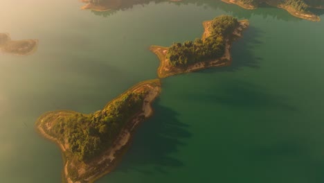 4K-aerial-drone-footage-of-small-islands-in-Kao-Sok-National-Park-during-a-sunrise,-Thailand,-Asia