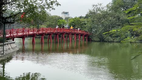 Red-Bridge-to-left---The-Huc-Bridge-over-Hoan-Kiem-Lake,-Hanoi,-Vietnam