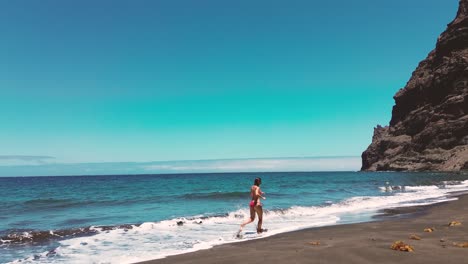 Frau-Läuft-Im-Sommer-Im-Urlaub-In-Zeitlupe-Am-Strand-Auf-Gran-Canaria,-Spanien