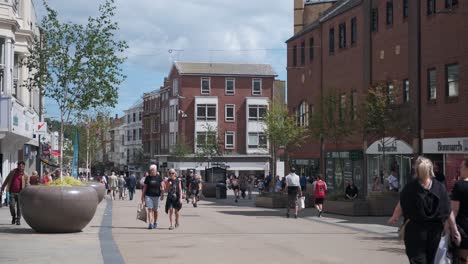 footage-of-Scarborough-town-centre,-North-Yorkshire-on-a-summer-day-on-a-busy-weekend-with-families-and-couples-walking-around-the-shops-in-the-town